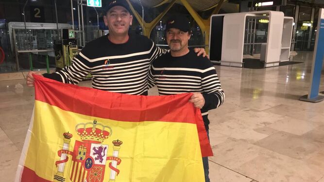 Pepe Ruiz (i) y su compañero posan con la bandera rojigualda en el aeropuerto de Barajas.