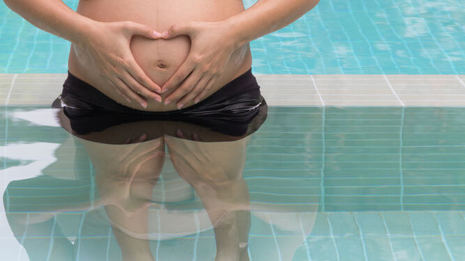 Imagen de archivo de una mujer embarazada en una clase preparto en una piscina.