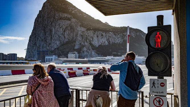 Un grupo de personas espera a que la actividad en el aeropuerto cese para llegar a Gibraltar.