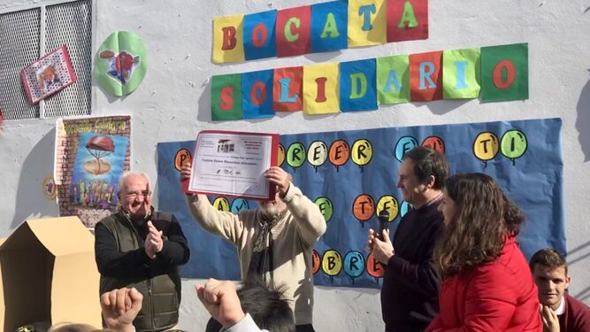 La comunidad educativa del colegio entrega el cheque solidario a los voluntarios de Cáritas.