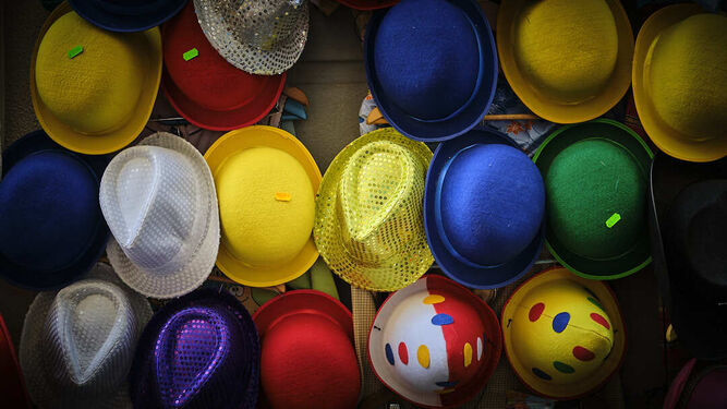 Sombreros de colores, a la venta en la puerta de un comercio.