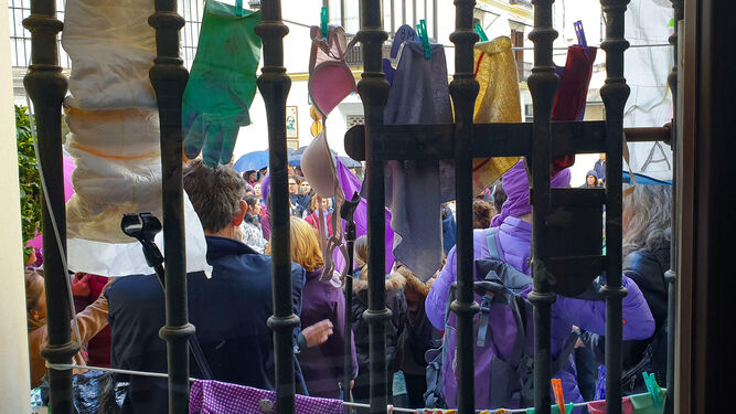 Dodotis, sujetadores, trapos y guantes de limpieza colgados de una ventana del Ayuntamiento.