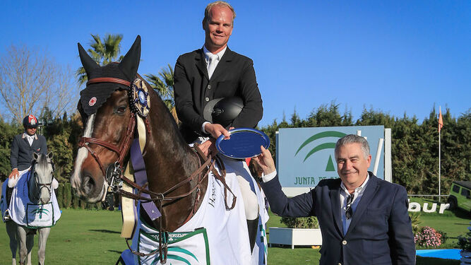El jinete ganador posa junto a su caballo en la ceremonia de entrega de premios.