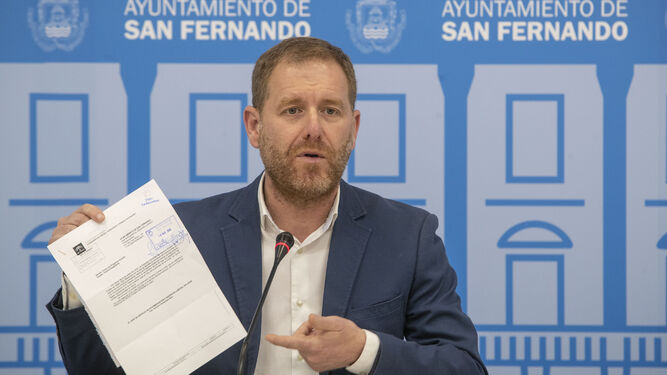 El concejal de Presidencia y Desarrollo Económico, Conrado Rodríguez, muestra el acuerdo de la Junta relativo al programa Andalucía Emprende.