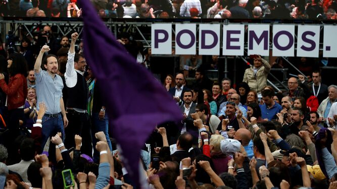 Pablo Iglesias, junto a Juan Carlos Monedero, alza el puño en el acto por su regreso en Madrid.