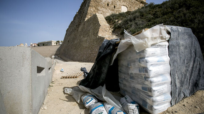 Dos palés repletos de sacos de mortero de cal se encuentran a los pies de la muralla del Baluarte de San Roque