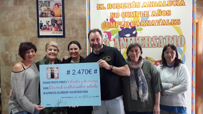Alfonso, del Bodegón Andalucía, entrega el cheque por valor de 2.470 euros a la asociación Valientes y Guerreras.
