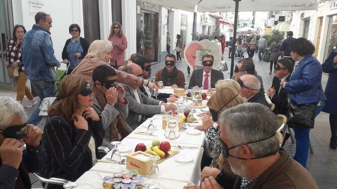 Un momento del desayuno a ciegas celebrado en la calle La Vega con la presencia de representantes municipales y de otros colectivos.