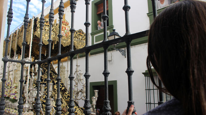 Una joven observa el paso de la Virgen de la Estrella desde un balcón