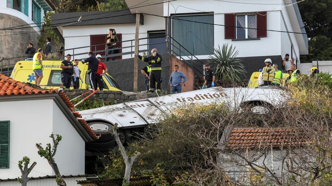 Rescatistas inspeccionan el lugar del accidente en el que un autobús chocó contra una vivienda en Madeira.