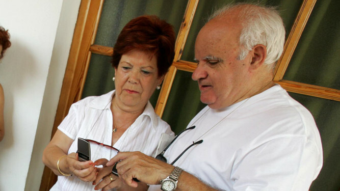 Dos mayores utilizando su teléfono móvil.
