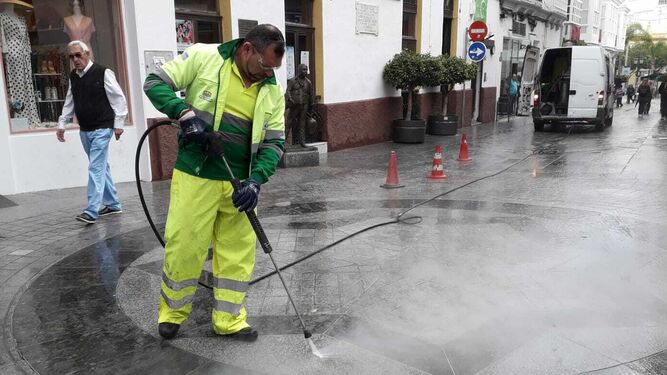 Un operario de los servicios de limpieza trabaja en la retirada de la cera de la calle.