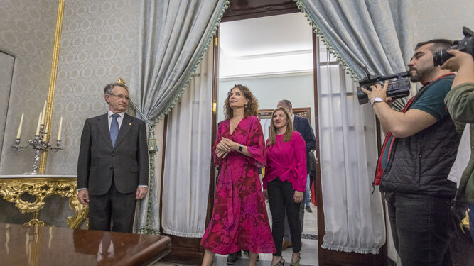 La ministra María Jesús Montero entra en el Salón Carlos IV de Diputación con Irene García.