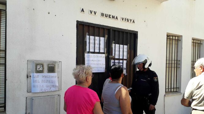Un agente de la Policía Nacional conversando con algunos de los vecinos que se concentraron el lunes en la puerta de la AVV.