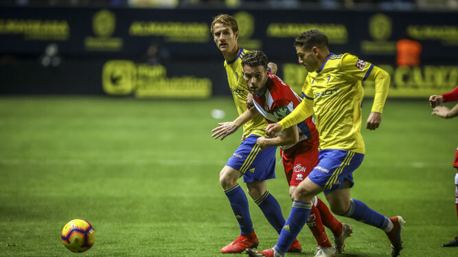 Manu Vallejo (d) y Álex Fernández acechan a un jugador del Granada en el partido de la primera vuelta.