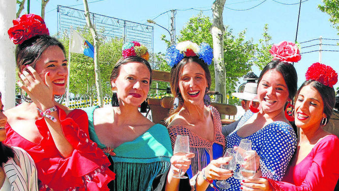 Un colorido grupo de jóvenes vestidas de flamenca.