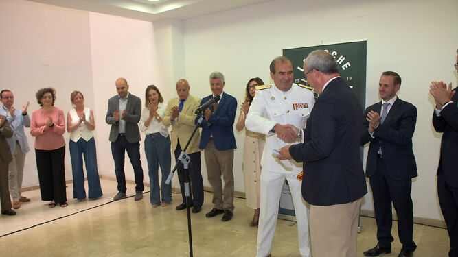avier Sánchez Rojas hace entrega de una bandera de España al almirante del Arsenal de Cádiz, Enrique Torres, en Cádiz, en la sede de la CEC.