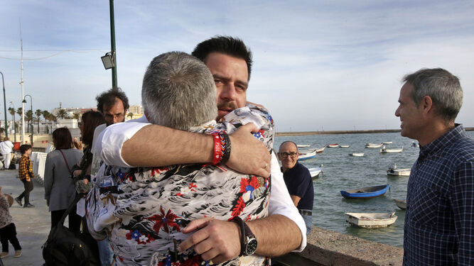 Fran González se abraza a un militante socialista tras intervenir en el acto de final de campaña en el Club Caleta.