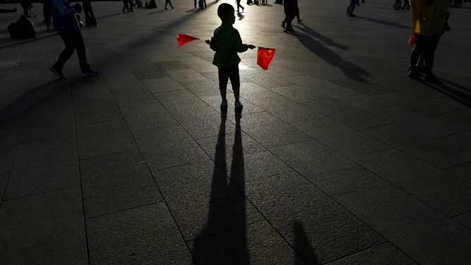 Un niño sostiene dos banderas en la plaza de Tiananmen de Pekín la semana pasada.