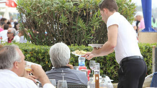 Un camarero atiende en una terraza de La Barrosa.