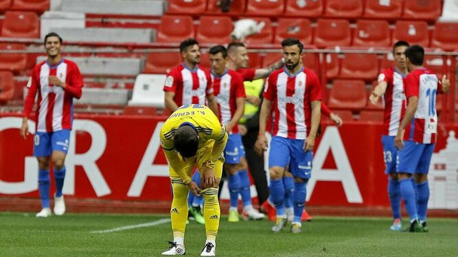 Espino se ajusta una media mientras los jugadores del Sporting celebran el gol en la última jornada.