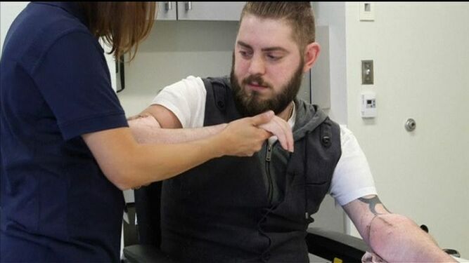 Una enfermera ayuda al soldado al que le han trasplantado dos brazos de un donante