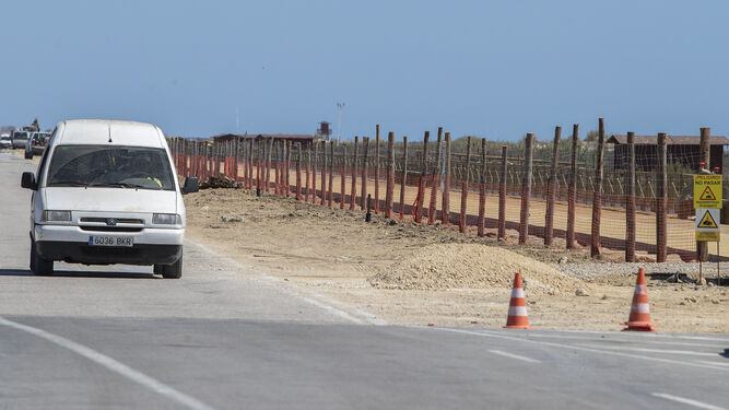 Una vehículo circula por la carretera de la playa de Camposoto hace unos días, mientras se trabajaba en la zona.