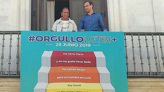 El alcalde y la concejala gobernante Teresa Rúa colocando esta mañana una pancarta en el balcón de la Biblioteca Municipal.
