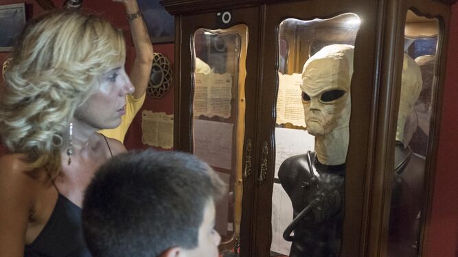 Dos personas observan la reproducción de un alienígena en una de las vitrinas.
