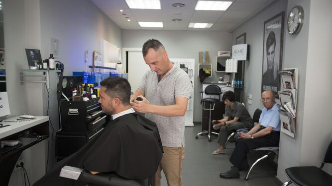 El peluquero Juan Barroso pelando a un cliente
