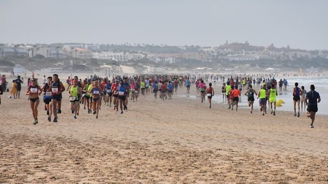 Los corredores recorren el circuito trazado por la arena de la playa.