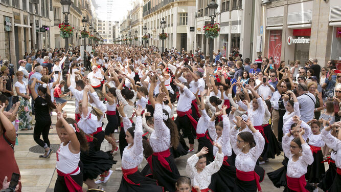 Miles de personas intentando batir un récord de baile de malagueñas en la calle Larios