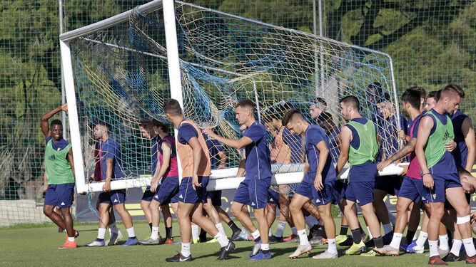 Los jugadores del Cádiz B afrontan la pesada carga de una portería en un entreno.
