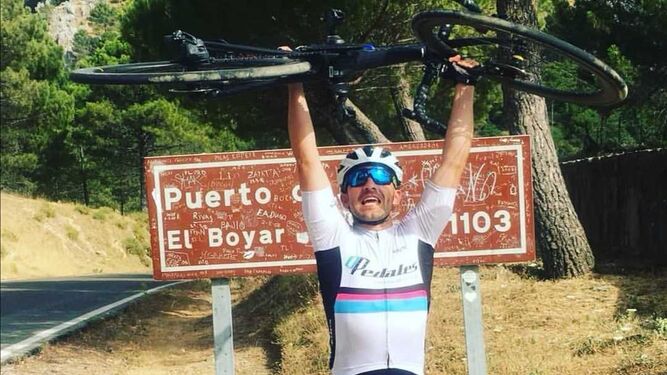 Fran Fajardo alza su bici delante del cartel indicativo del puerto de El Boyar.