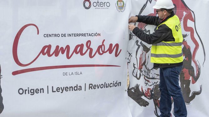 Un operario, el día de la colocación de la primera piedra, coloca un cartel promocional del Museo Camarón.