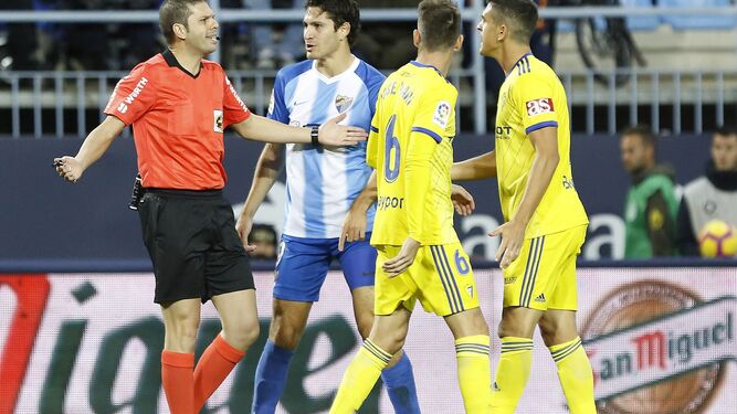 Leschuk se dirige al árbitro en presencia de José Mari y Garrido durante el último Málaga-Cádiz.