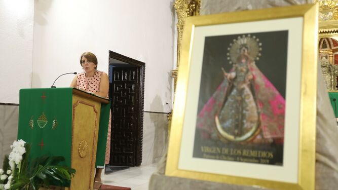 Inma Parra frente al cartel de anunciador de la festividad de la Patrona.