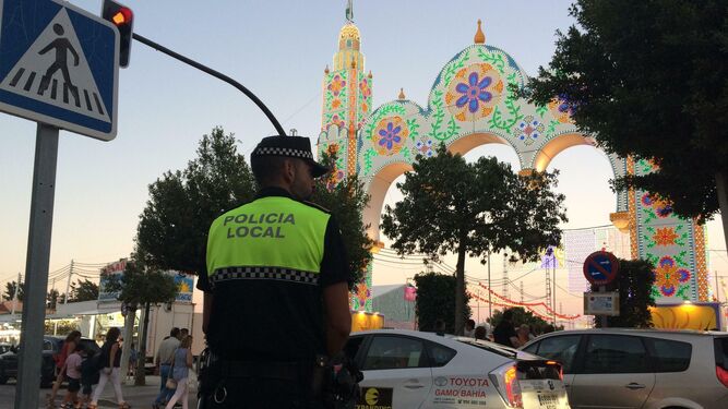 Un Policía Local frente a la portada de la Feria, controlando el tráfico.