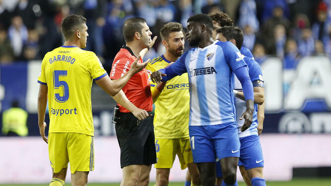 Trujillo Suárez discute con jugadores del Málaga en el partido frente al Cádiz en La Rosaleda.