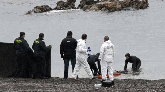 La Guardia Civil rescata en la playa del Tarajal de Ceuta el cadáver de uno de los  15 subsaharianos fallecidos en febrero de 2014 al tratar de llegar a nado a la costa.