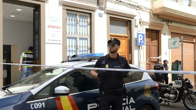 Un policía vigila el edificio de Las Palmas de Gran Canaria donde un hombre ha matado a su expareja y, después, se ha suicidado.