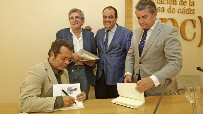 Juan Manuel Marqués firma un ejemplar de su libro en presencia de Luis Pizarro, David Fernández y Antonio Sanz.