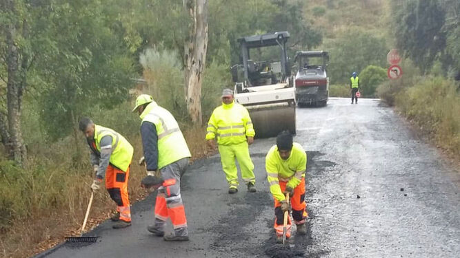Un grupo de operarios arreglando el firme de una carretera en la Sierra.