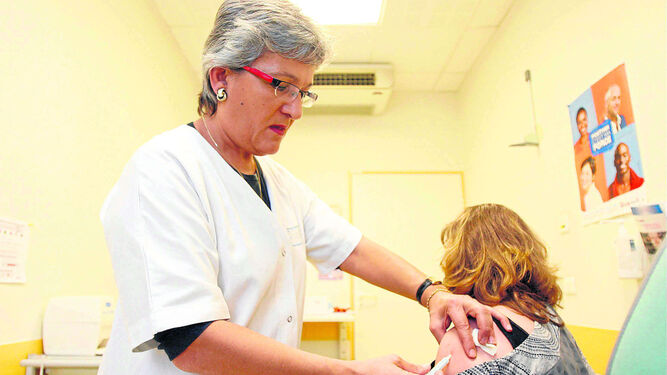 Una especialista vacunando a una paciente.
