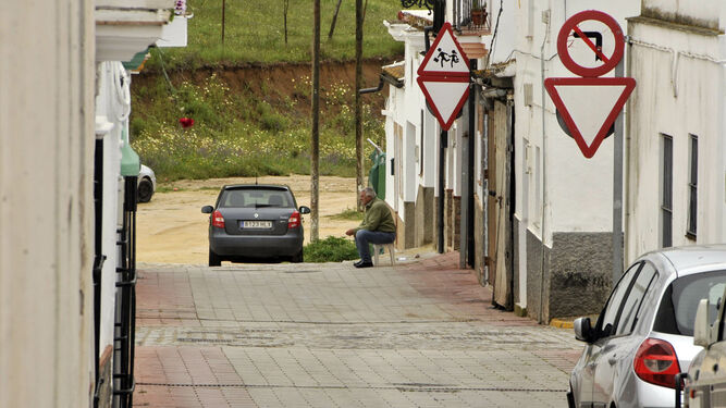 Un vecino de Algar sentado ante la puerta de su casa en una de sus calles.