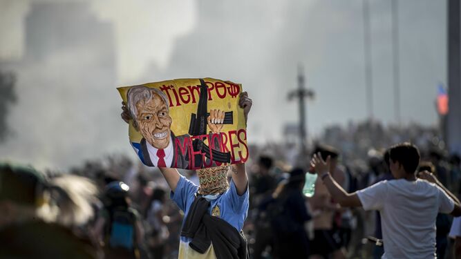 Un manifestante chileno porta una pancarta contra el presidente del país, Sebastián Piñera.