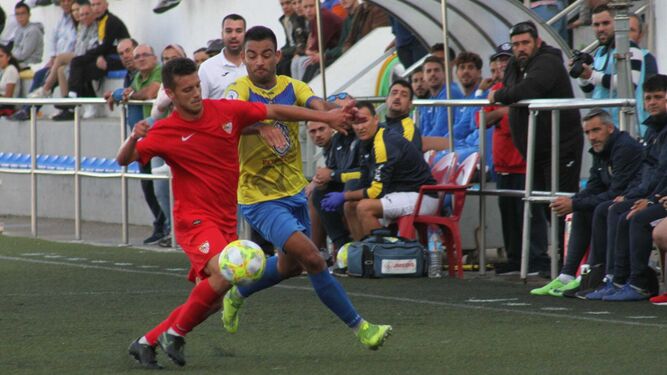 Cuenca, autor del único gol del partido, pugna con un jugador sevillista.