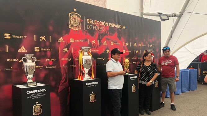 Aficionados posan junto a trofeos conquistados por la selección española.