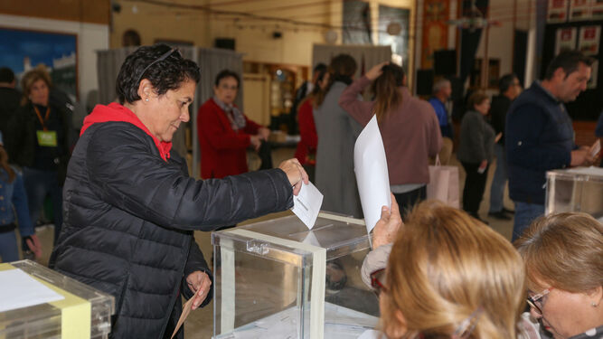 Una mujer introduce la papeleta en una urna de un colegio electoral de Chiclana.