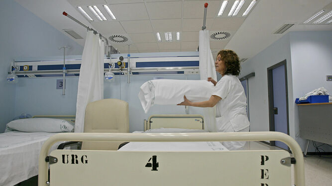 Imagen de archivo de una profesional haciendo una de las camas de la Unidad de Pediatría del Puerta del Mar.